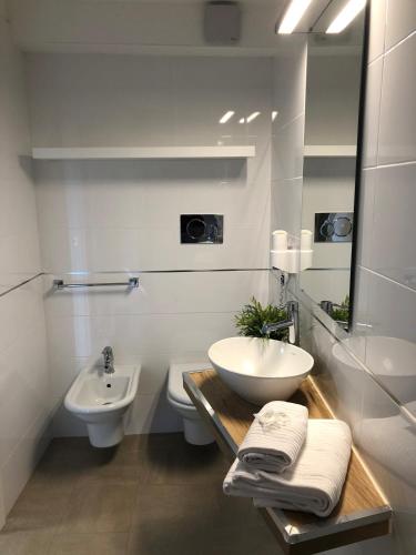 a bathroom with a sink and a toilet and a mirror at Hotel Isola Verde in Nago-Torbole