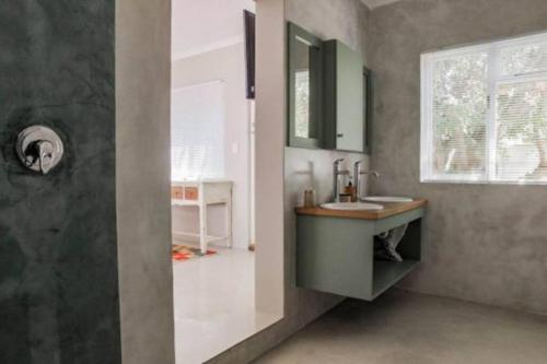 a bathroom with a sink and a shower at Angel's Place by the Sea in Hermanus