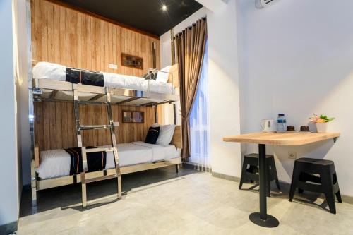 ジョグジャカルタにあるSuper OYO Collection O 2627 Ratamya Co-livingの二段ベッド2台、デスクが備わる客室です。
