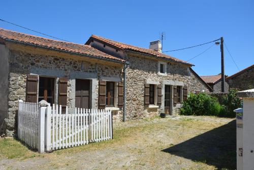 an old stone house with a white fence at Villa Gites Chambre d hôtes avec piscine Dordogne 2-4-6-8-10 personnes in Bussière-Badil