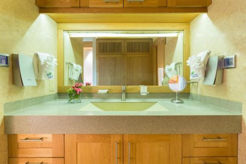 a bathroom with a sink and a large mirror at One ON Marlin Resort in Turtle Cove