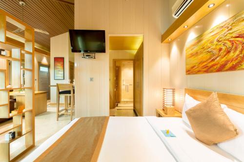 a bedroom with a bed with a tv on the wall at One ON Marlin Resort in Turtle Cove
