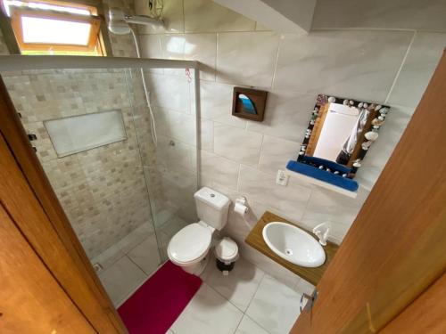 a bathroom with a toilet and a sink and a shower at Noah Rosa Chalés in Praia do Rosa