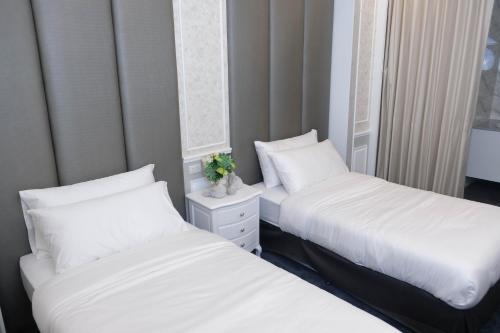 two beds sitting next to each other in a bedroom at VARIMANTRA HOTEL in Nakhon Pathom
