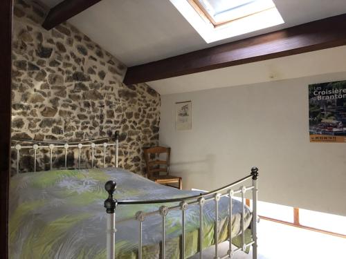 a bedroom with a bed in a stone wall at Villa Gites Chambre d hôtes avec piscine Dordogne 2-4-6-8-10 personnes in Bussière-Badil