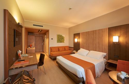 ラメーツィア・テルメにあるTHotel Lameziaの大きなベッドとソファが備わるホテルルームです。