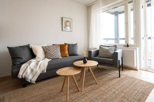 a living room with a couch and a chair and a table at Roost Rantatie 18 in Tampere