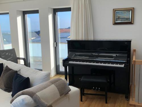 a living room with a piano and a couch at Tor zum Meer in Helgoland