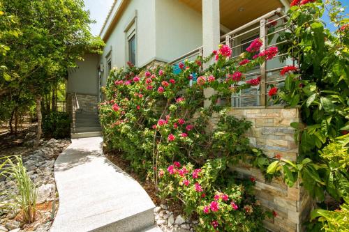 a house with pink flowers on the side of it at One ON Marlin Resort in Turtle Cove