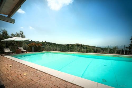 a large blue swimming pool with a fence at Agriturismo La Gioconda in Vinci