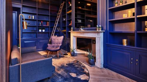 een blauwe kamer met een stoel en een open haard bij Staybridge Suites The Hague - Parliament, an IHG Hotel in Den Haag