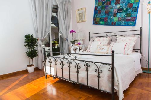 1 dormitorio con 1 cama con sábanas blancas y almohadas rosas en B&B Stupor Mundi, en Altamura
