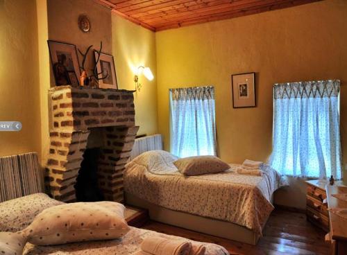 a bedroom with two beds and a fireplace at Villas De Luna in Sidhirokhórion