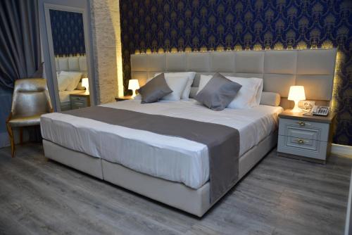 a bedroom with a large bed and a chair at The King Resort in Tirana