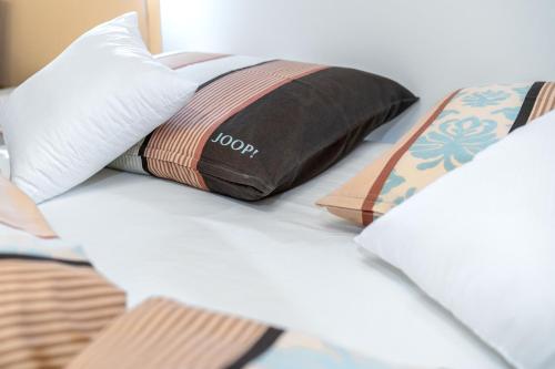 a bed with two pillows on top of it at Adria Sun Apartments in Vodice