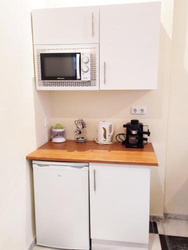 a kitchen with white cabinets and a microwave at Apartamento Córdoba centro in Córdoba