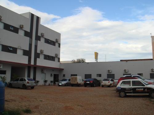 a large building with cars parked in a parking lot at Hotel São Paulo in Rondonópolis