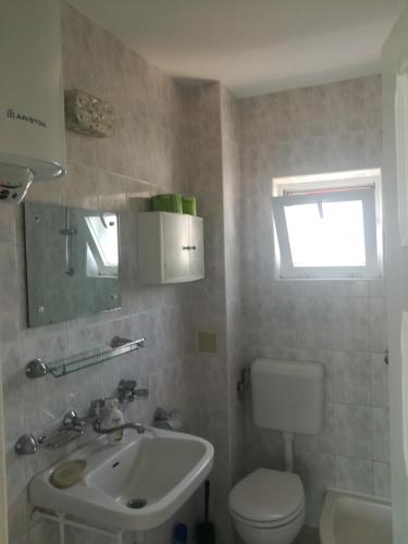 a bathroom with a sink and a toilet and a window at Cozy studio #1, with balcony in 2 Mai