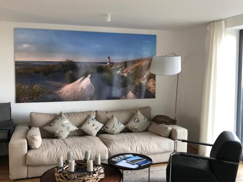 a living room with a couch and a picture of a beach at Tor zum Meer in Helgoland