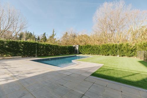 a swimming pool in a yard with a lawn at CIM Aparthotel in Sant Cugat del Vallès