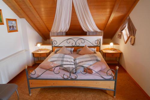 a bedroom with a bed with pillows and two tables at Bergbauernhof Weber in Bad Hindelang