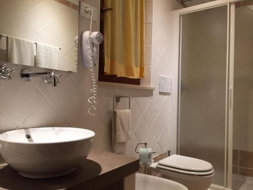 a bathroom with a sink and a toilet and a shower at Hotel Il Caminetto in Portoferraio