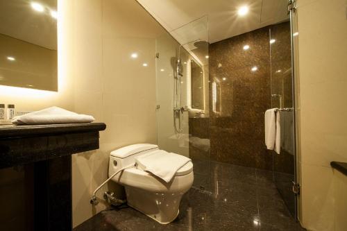 a bathroom with a toilet and a shower at Avenzel Hotel & Convention Cibubur in Cibubur