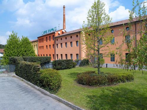 a large building with a tree in front of it at Hotel Filanda in Cittadella