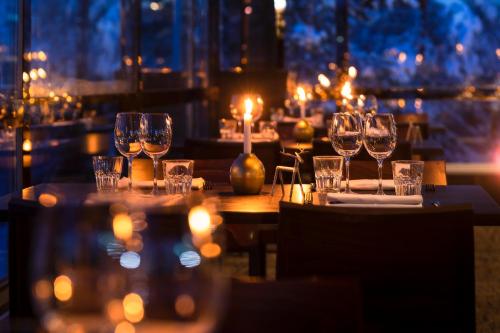 a table in a restaurant with wine glasses on it at Lapland Hotels Sky Ounasvaara in Rovaniemi