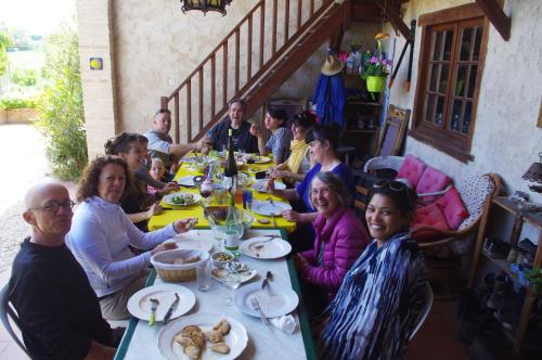 een groep mensen die aan een tafel zitten te eten bij Le Grangé in Giscaro