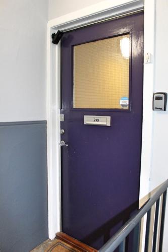 a purple door with a window on it at Castlehill Apartment in Stirling