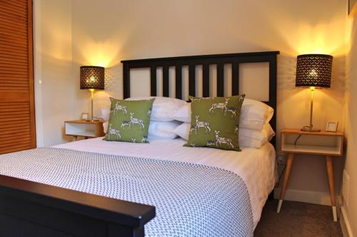 a bedroom with a large bed with two lamps at Castlehill Apartment in Stirling