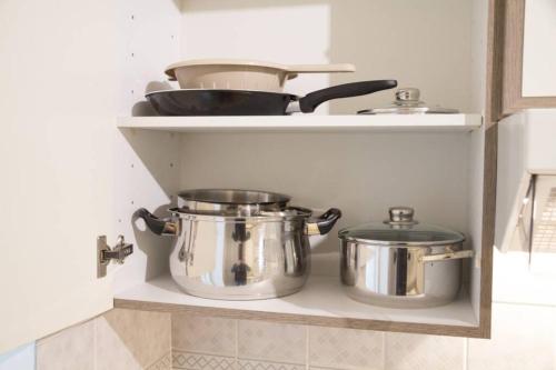 duas panelas e frigideiras numa prateleira numa cozinha em Vienna4you App 20 you are welcome em Viena