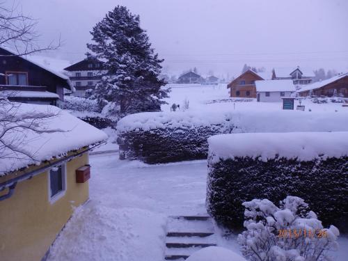 a yard covered in snow next to a house at Apartments Haus Steinbock in Tauplitz