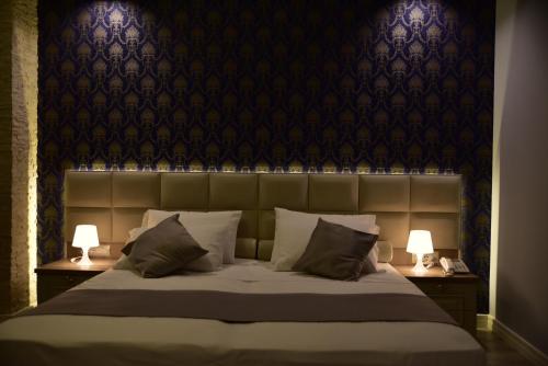 a bedroom with a large bed with two lamps at The King Resort in Tirana