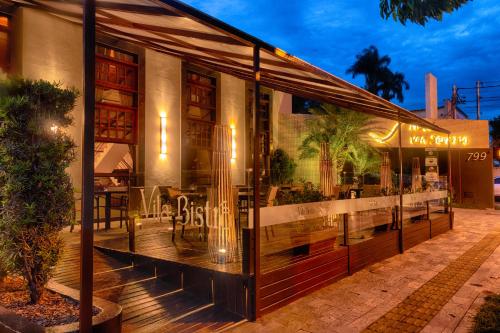 un restaurante con una gran ventana de cristal en un patio en Hotel Vila Serrana, en Sete Lagoas