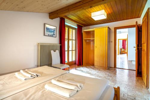 a bedroom with a bed with towels on it at Chalet SONNECK Summer Card included in Kaprun