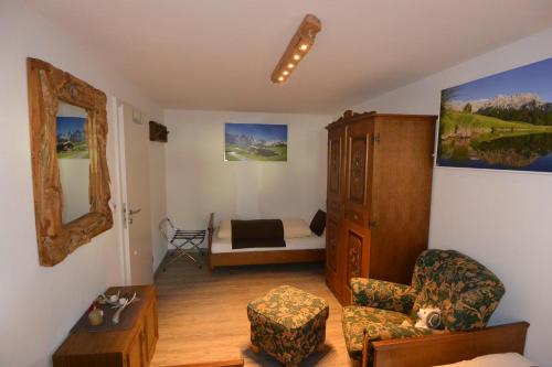 a living room with a bed and a chair at Haus Erli in Mittenwald
