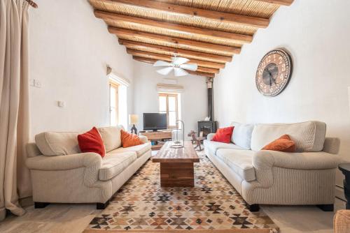 a living room with two couches and a table at The Carob Tree Villa - 3 BR Rustic Luxury Home in Larnaca