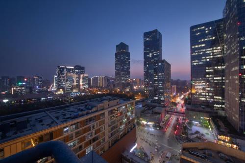 uma vista para o horizonte da cidade à noite em Holiday Inn Express Zhengzhou Zhengdong, an IHG Hotel em Zhengzhou