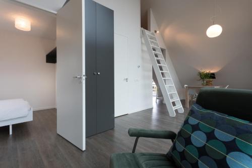 ein Wohnzimmer mit einer grünen Couch und einer Leiter in der Unterkunft ParelDuyn in Oostkapelle