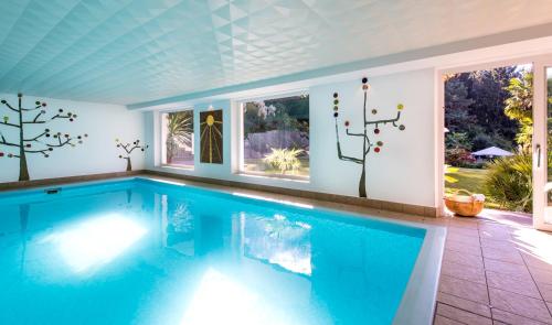 a swimming pool in a house with a window at Alpwellhotel Burggräfler in Tesimo