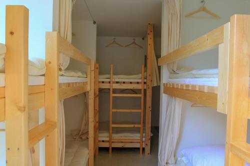 a room with three bunk beds in a room at plumhostel in Odawara