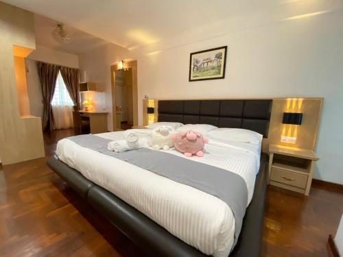 a bedroom with a bed with a stuffed animal on it at Century Suria Aparment Langkawi by Zervin in Kuah