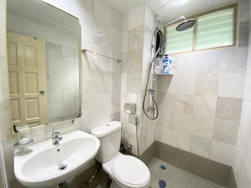 a bathroom with a toilet and a sink and a mirror at Century Suria Aparment Langkawi by Zervin in Kuah