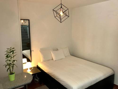 a small bed in a room with a lamp at Firmeza 358 studios - street level in Porto
