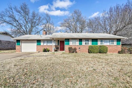 a red brick house with a white garage at Norman Home with Yard, Walk to Park and OU Campus! in Norman
