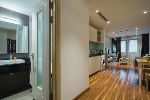 a kitchen and living room with a sink and a table at Ficus Suites in Hanoi