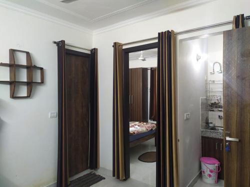 een badkamer met een spiegel en een deur in een kamer bij The Raveesh Lado - 1BHK Fully Furnished Apartment in New Delhi