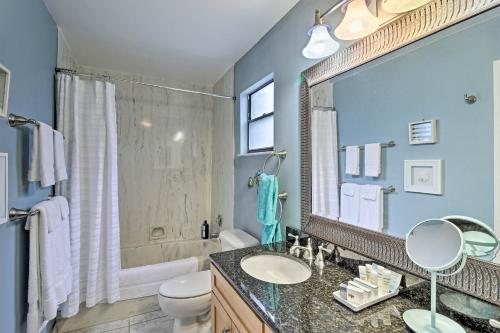 a bathroom with a sink and a toilet and a mirror at Jensen Beach Home with Pool Access Less Than 1 Mi to Beach! in Jensen Beach